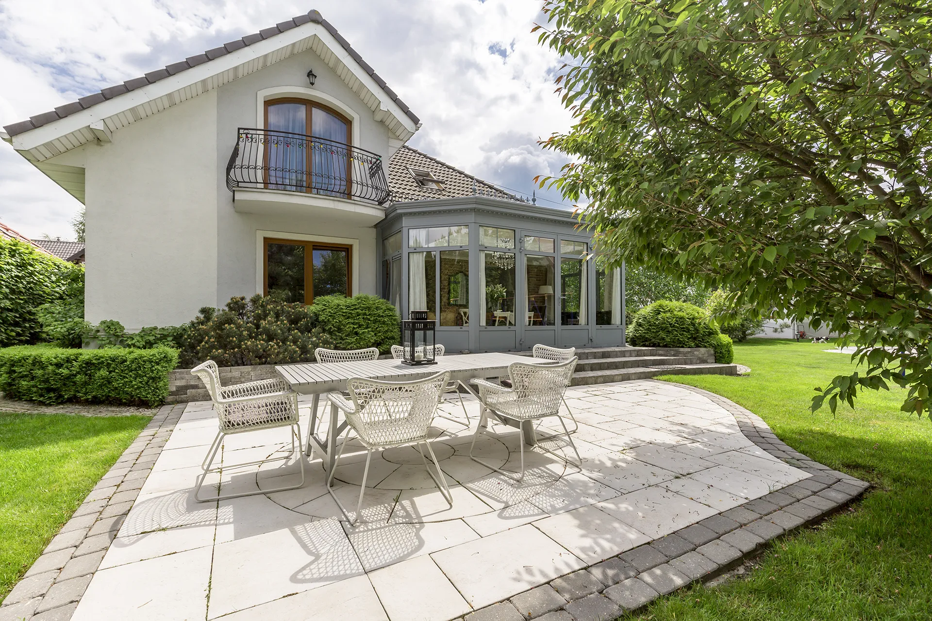 Stamped concrete patio with outdoor dining set beside a modern house.
